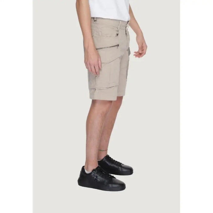 Beige cargo shorts with pockets paired with black sneakers from Replay Men’s collection