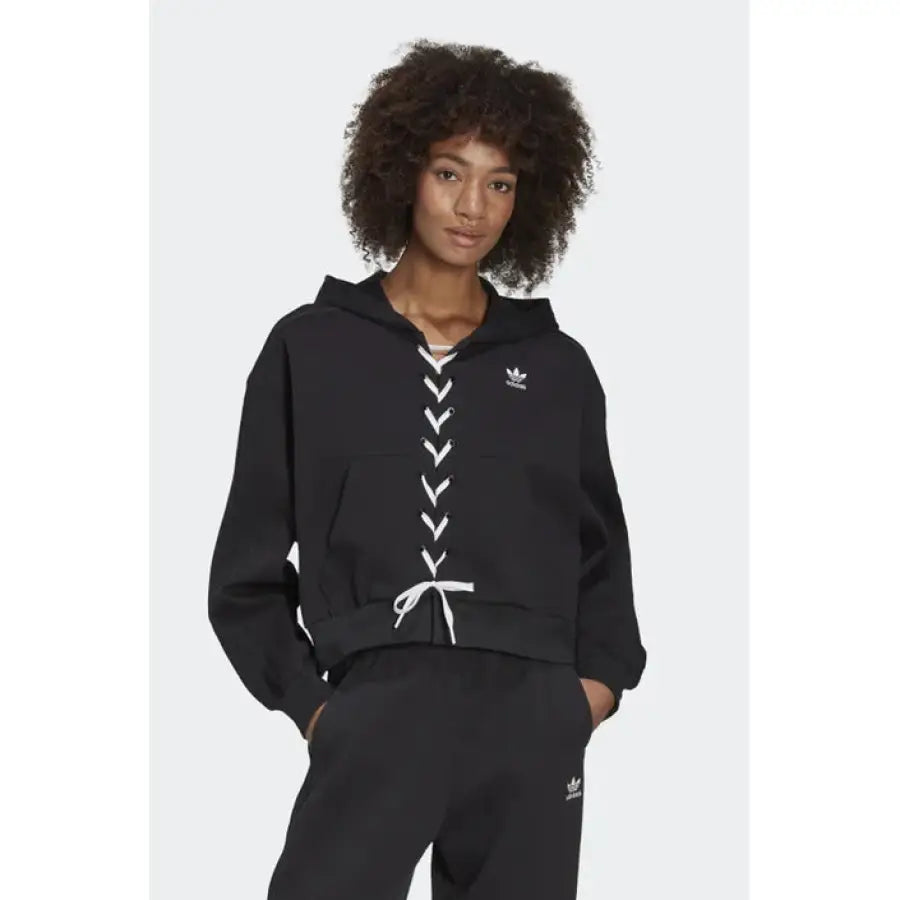 
                      
                        Black Adidas women’s hoodie with white lace-up detailing down the front
                      
                    