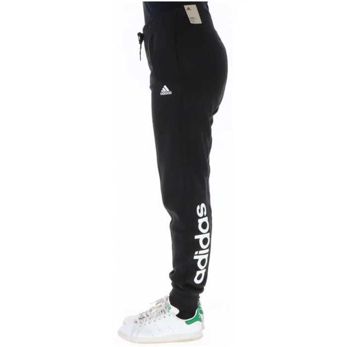 Black Adidas sweatpants featuring a white logo on the leg for women