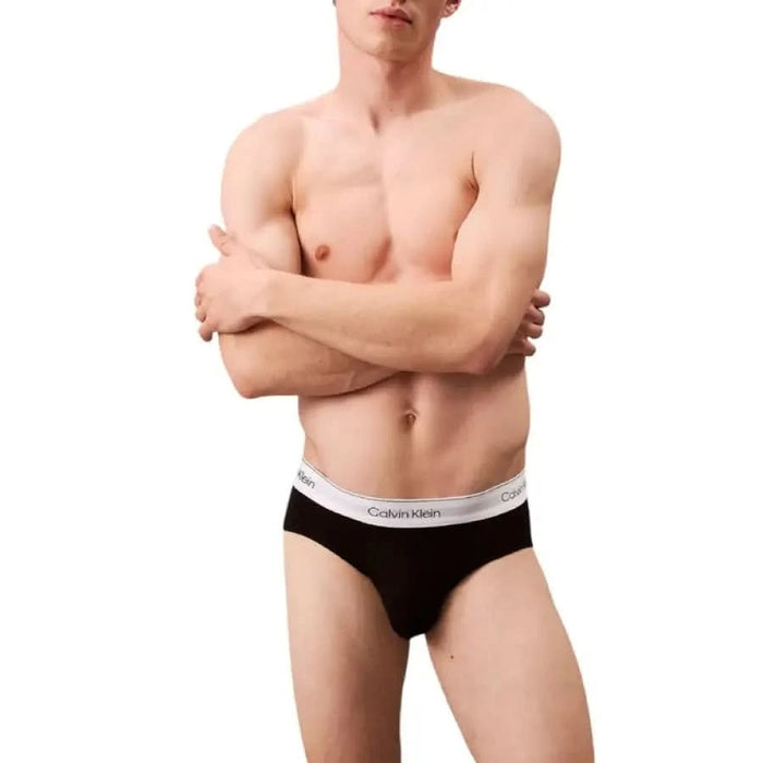 Black Calvin Klein briefs featuring a white elastic waistband for men’s underwear