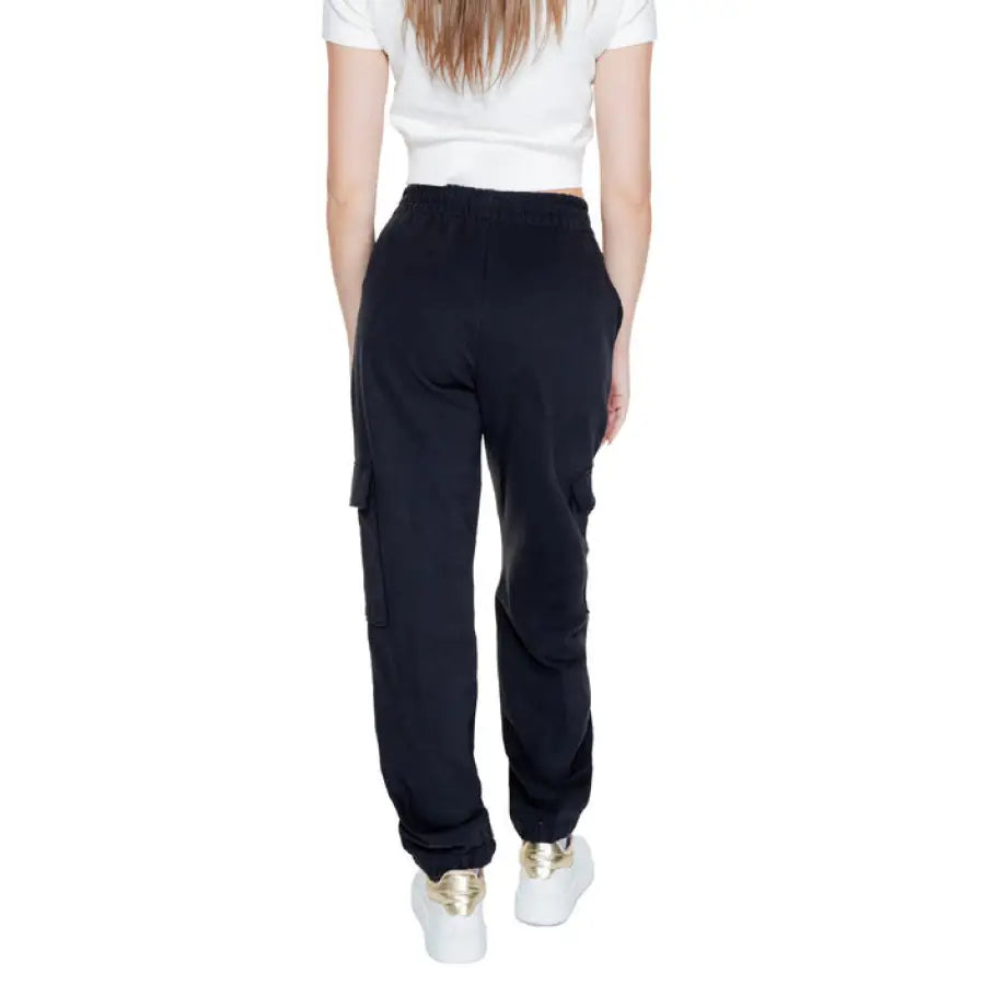 Calvin Klein black cargo pants paired with a white crop top and white sneakers