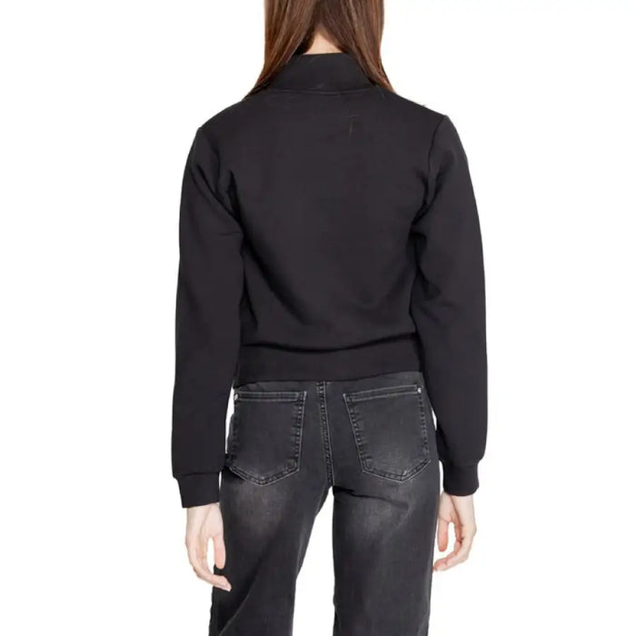 Black cropped bomber jacket worn by a person with long brown hair from Guess Active