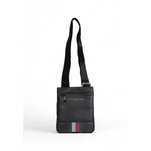 Black Tommy Hilfiger crossbody messenger bag with striped accent at the bottom