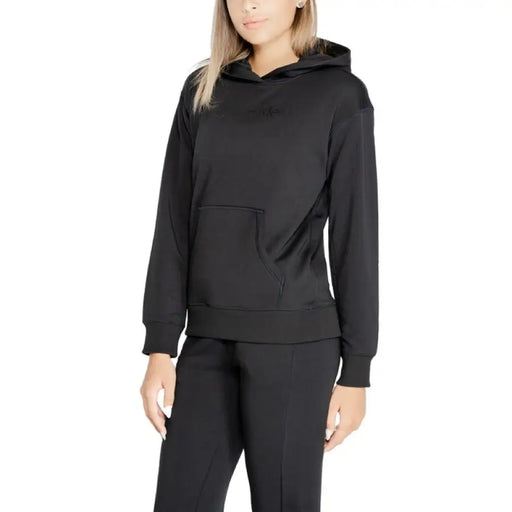 Black hooded sweatshirt worn by a person with long blonde hair from Calvin Klein Sport