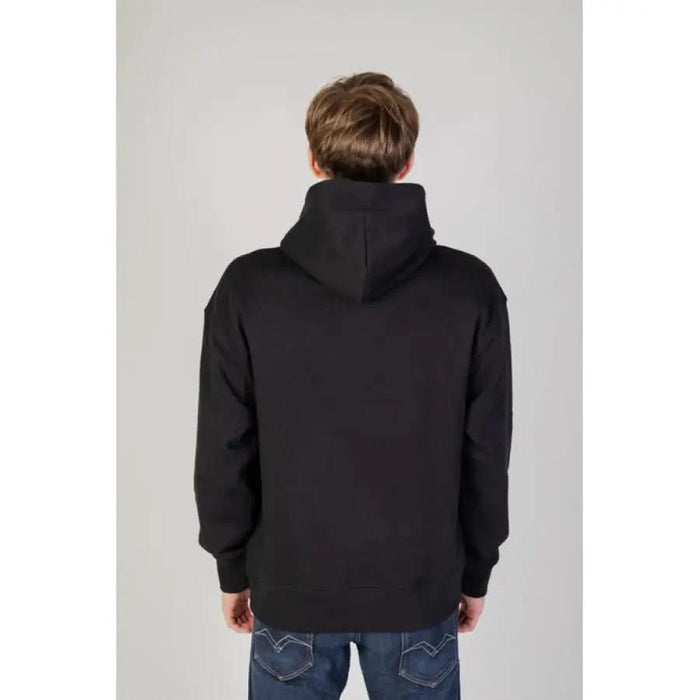 Person wearing a Black Tommy Hilfiger Hooded Sweatshirt, back view