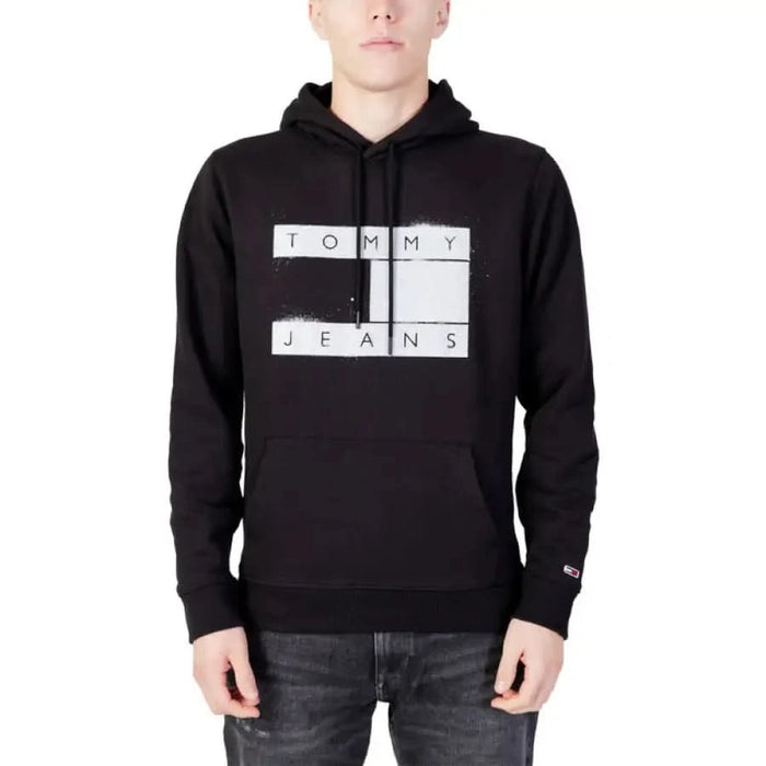 Black hoodie with ’TOMMY JEANS’ logo, featured in Tommy Hilfiger Jeans Men Sweatshirts collection