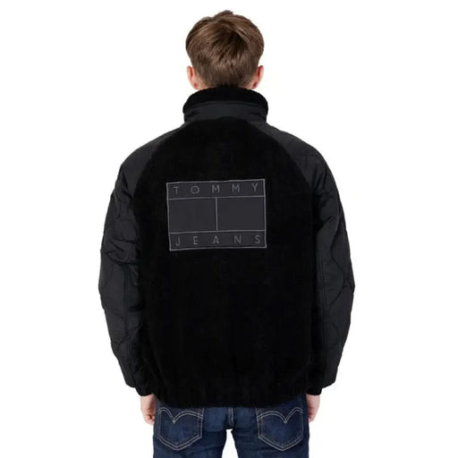 Black jacket featuring Tommy Jeans logo on the back, part of Tommy Hilfiger Jeans collection