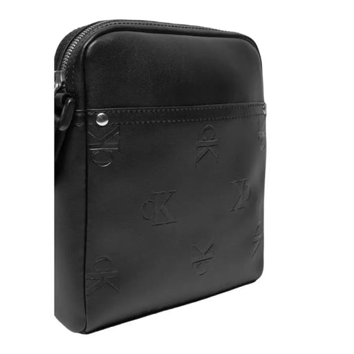 Black leather crossbody bag with embossed pattern and zipper closure by Calvin Klein