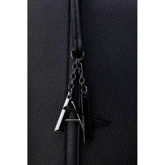 Black leather handbag with metal letter charms on zipper pull by Armani Exchange