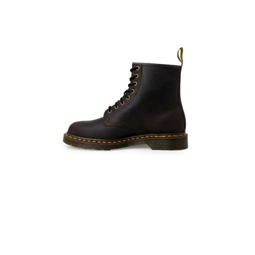 Black leather lace-up combat boot with yellow stitching and chunky sole by Dr. Martens