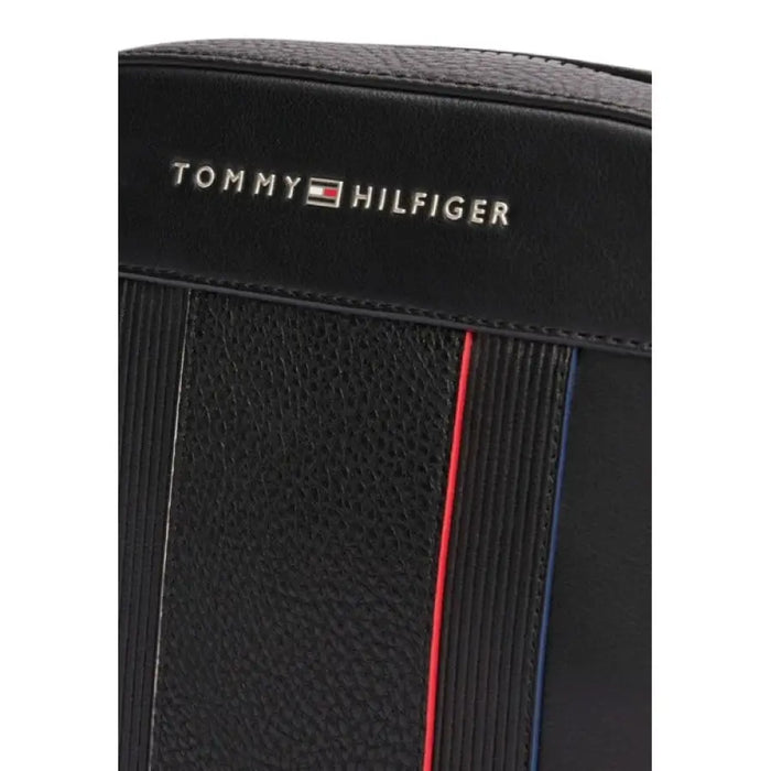 Black leather Tommy Hilfiger wallet with red and blue stripes, featured in men’s shoulder bag