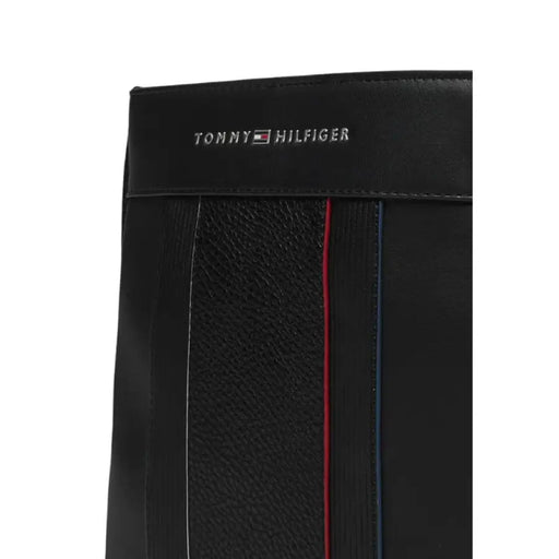 Black leather Tommy Hilfiger wallet with red and blue accents displayed with shoulder bag