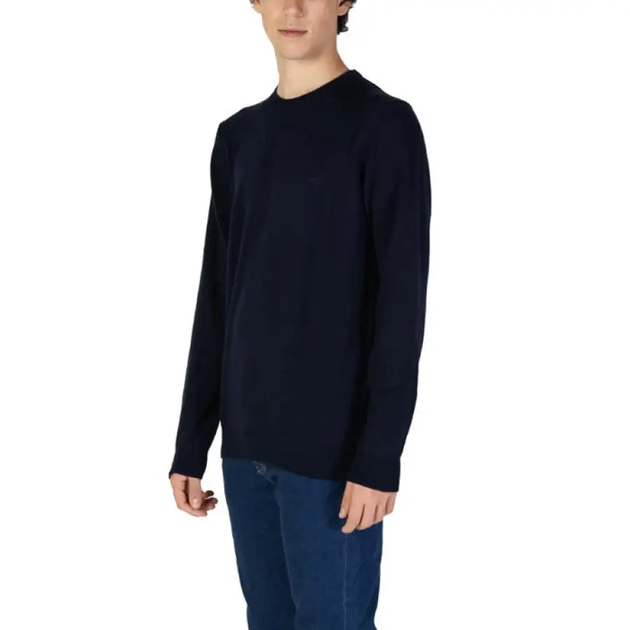 Black long-sleeve crewneck sweater paired with blue jeans from Gas Men collection