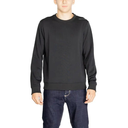 Black long-sleeved crewneck sweater worn by a model from Calvin Klein Sport collection