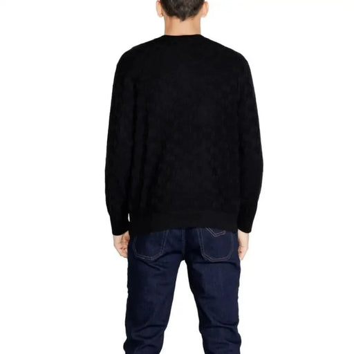 Black long-sleeved sweater worn by a person from behind, part of Armani Exchange Men Knitwear