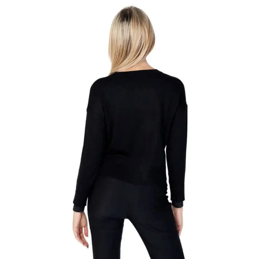 Blonde woman wearing a black long-sleeved top from Gaudì Jeans Women Knitwear, back view