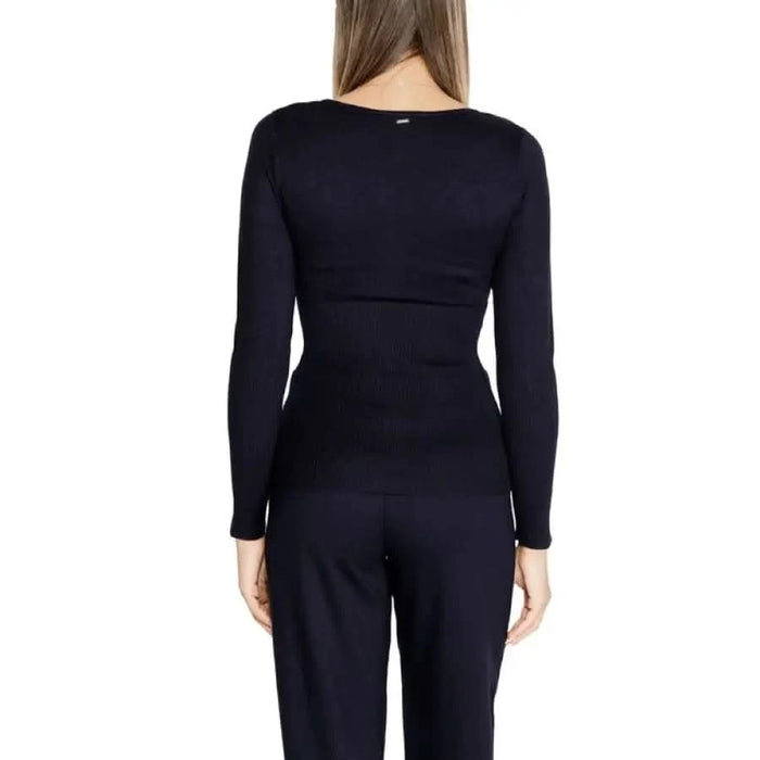 Black long-sleeved top by Morgan De Toi worn by a woman, viewed from behind