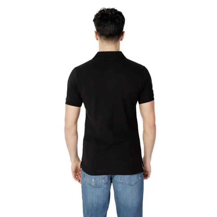 Black polo shirt worn by a person from behind, showcasing Tommy Hilfiger Jeans style