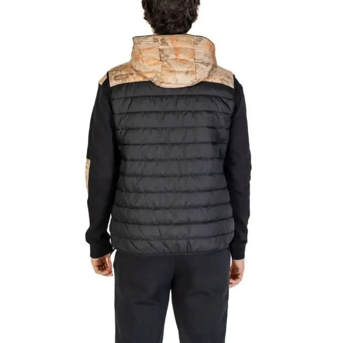 Black quilted vest with tan shoulders and hood worn from behind by model for Alviero Martini