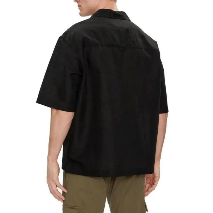 Calvin Klein Jeans Men’s black short-sleeved collared shirt viewed from the back