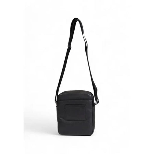 Black shoulder bag with single strap and textured exterior by Tommy Hilfiger