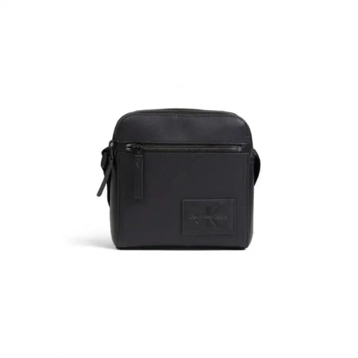 Black square crossbody bag with zipper compartments and logo patch by Calvin Klein