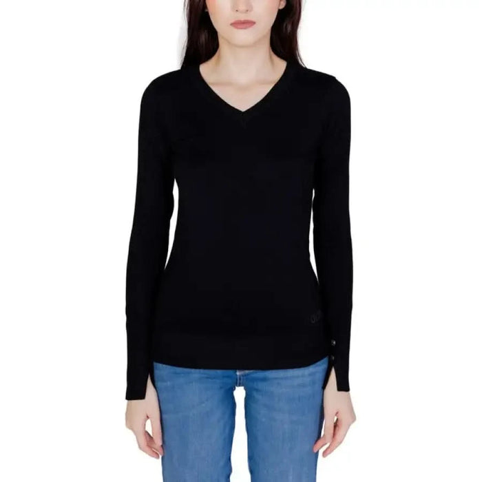 Guess Women Knitwear: Black v-neck long-sleeved sweater paired with blue jeans