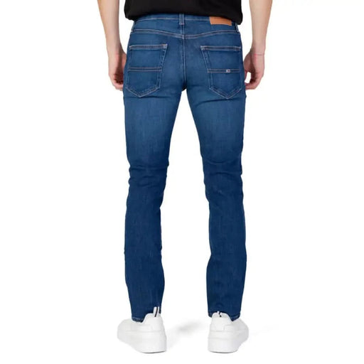 Blue denim jeans by Tommy Hilfiger worn by a person, viewed from behind