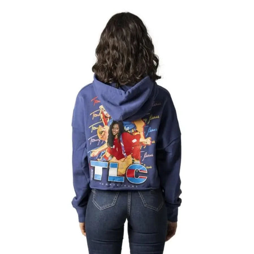 Blue hoodie featuring TLC design, worn by person with long dark curly hair - Tommy Hilfiger