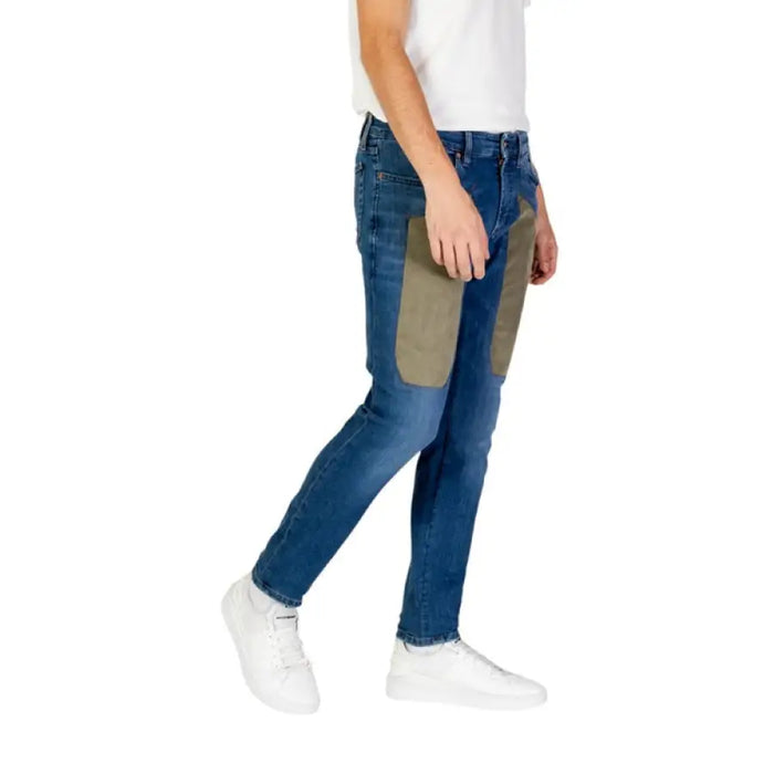 Blue Jeckerson Men’s Jeans featuring an olive patch on the thigh, zip, and button closure