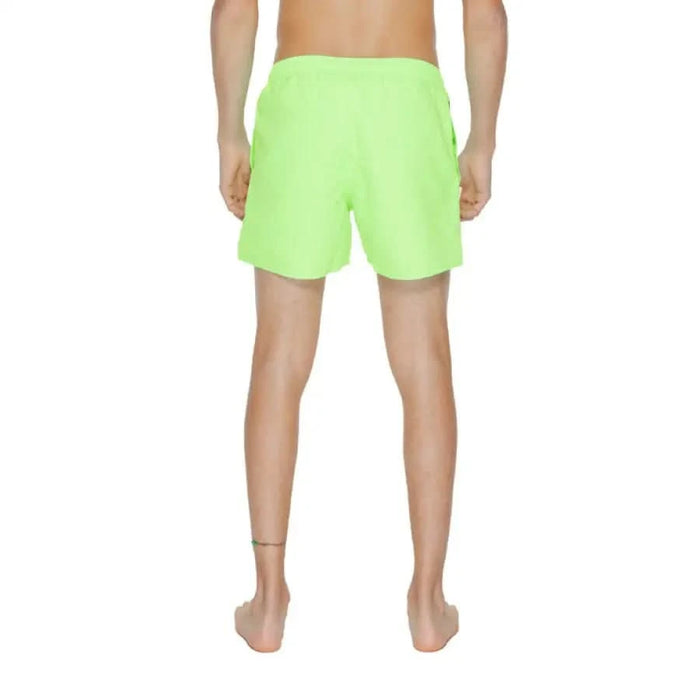 Bright neon green swim shorts in Ea7 Men Swimwear collection worn by person, view from behind