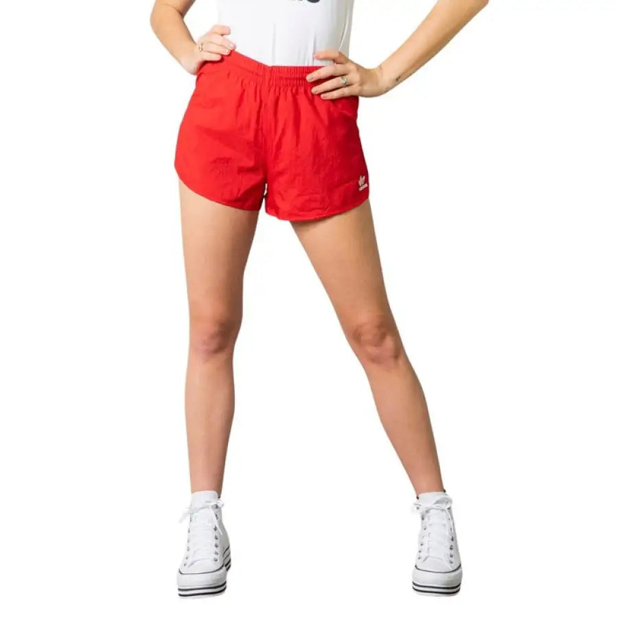 Adidas Women Short: Bright red athletic shorts worn with white sneakers