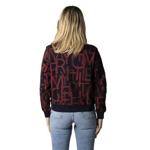 Burgundy and black patterned Tommy Hilfiger Jeans sweatshirt worn by a person from behind