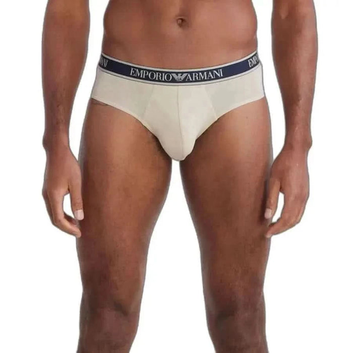 Cream-colored men’s briefs with Emporio Armani waistband worn by a model