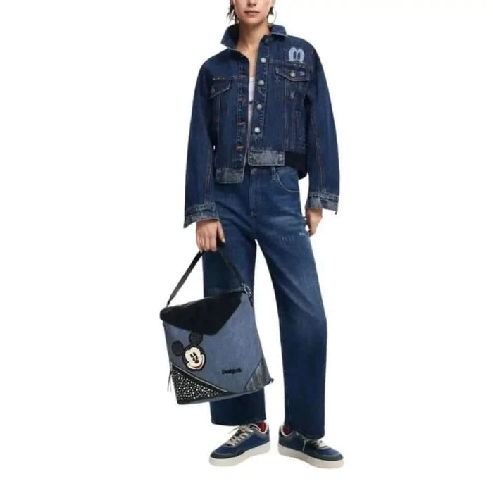 Denim jacket and jeans outfit styled with a handbag and sneakers by Desigual