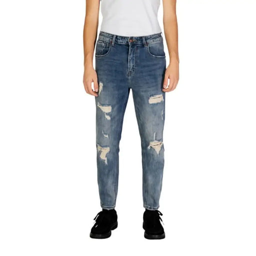 Distressed blue denim jeans by Gianni Lupo featuring ripped knees and fading details