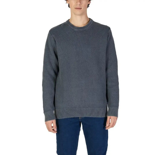 Gray knit crewneck sweater paired with blue jeans for men’s fashion styling