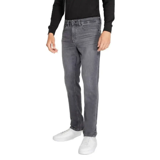 Gray straight-leg denim jeans paired with a black sweater and white sneakers from Boss