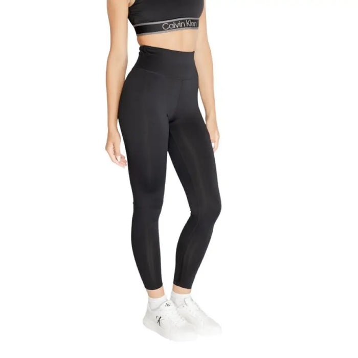 High-waisted black leggings with cropped top and white sneakers by Calvin Klein Sport