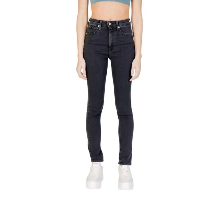 Calvin Klein high-waisted black skinny jeans worn by model in cropped top