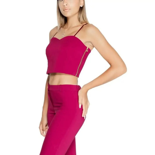 Hot pink two-piece outfit featuring a cropped bustier top and fitted pants by Rinascimento