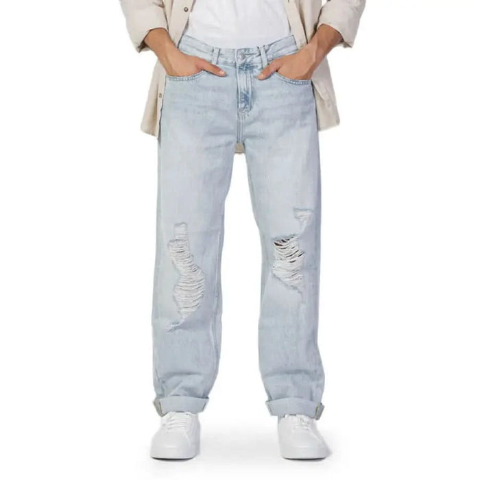 Light blue distressed Calvin Klein jeans featuring knee rips for a stylish look