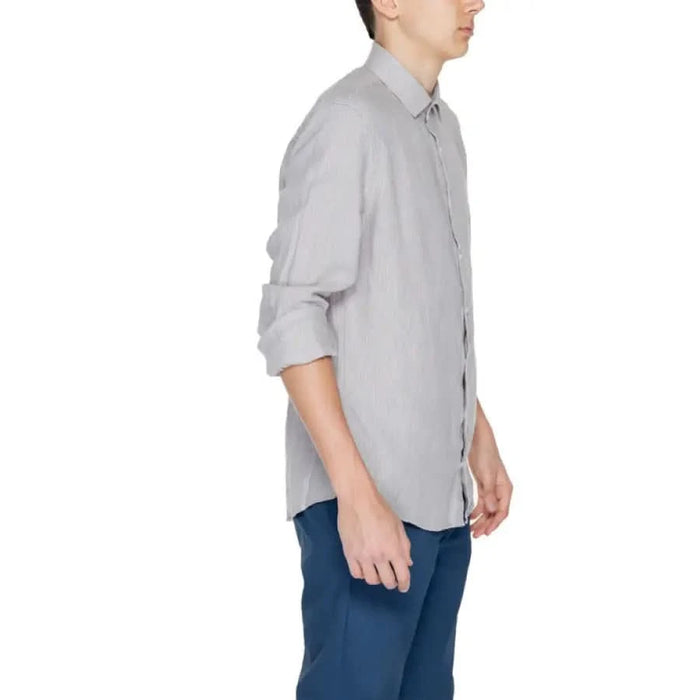 Calvin Klein light gray button-up shirt with rolled-up sleeves, paired with blue pants