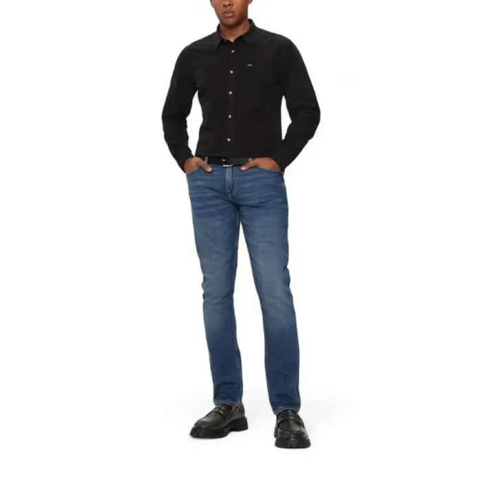 Man in black button-up shirt and blue jeans from Guess - Guess Men Jeans collection