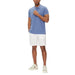 Man in light blue polo shirt and white shorts with white sneakers by Tommy Hilfiger Jeans