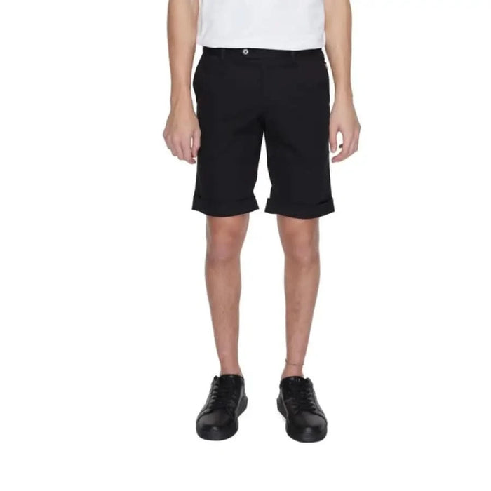 A man in a white t-shirt and Alviero Martini Prima Classe black shorts