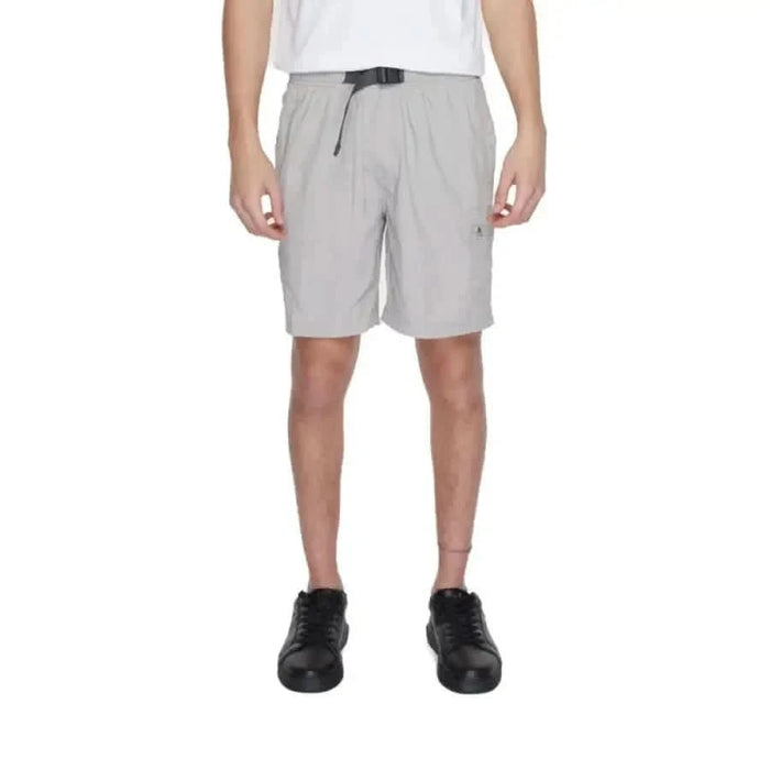 Man in urban style clothing with white t-shirt and grey Columbia shorts