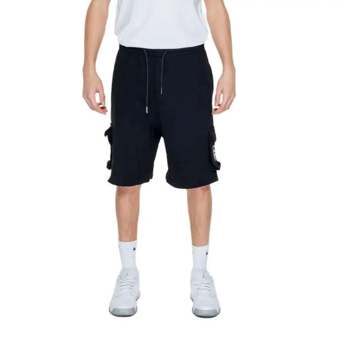 Man in white T-shirt and black Pharmacy Men Shorts by Pharmacy