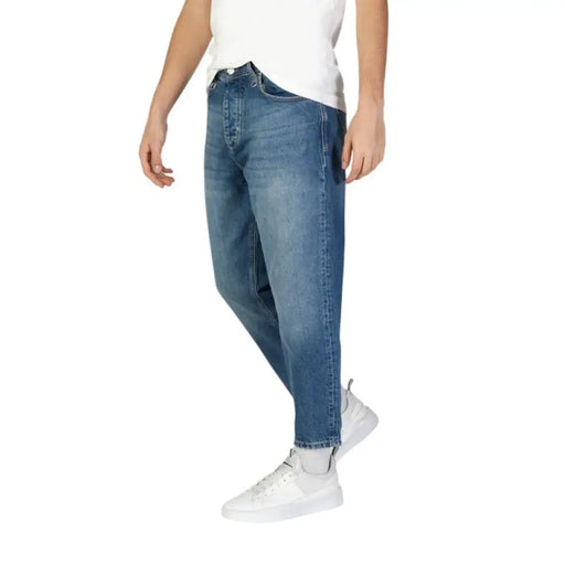 Medium-wash denim jeans with relaxed fit paired with white sneakers by Antony Morato