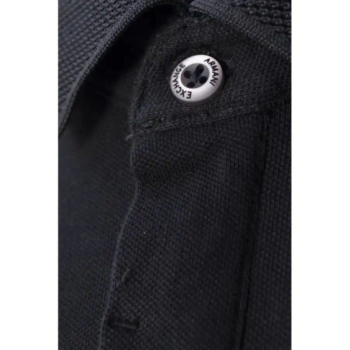 Metal snap button on black fabric of Armani Exchange Men Polo garment